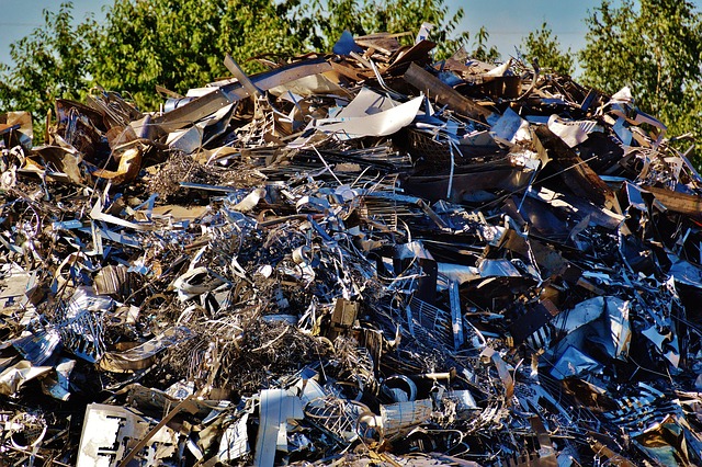 Hoop metaalafval op een terrein van een metaalrecyclingbedrijf, bestaande uit verroeste en glimmende metalen onderdelen
