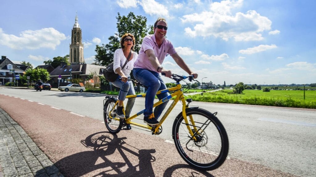 Twee personen op een elektrische fiets passend bij een fietsverzekering