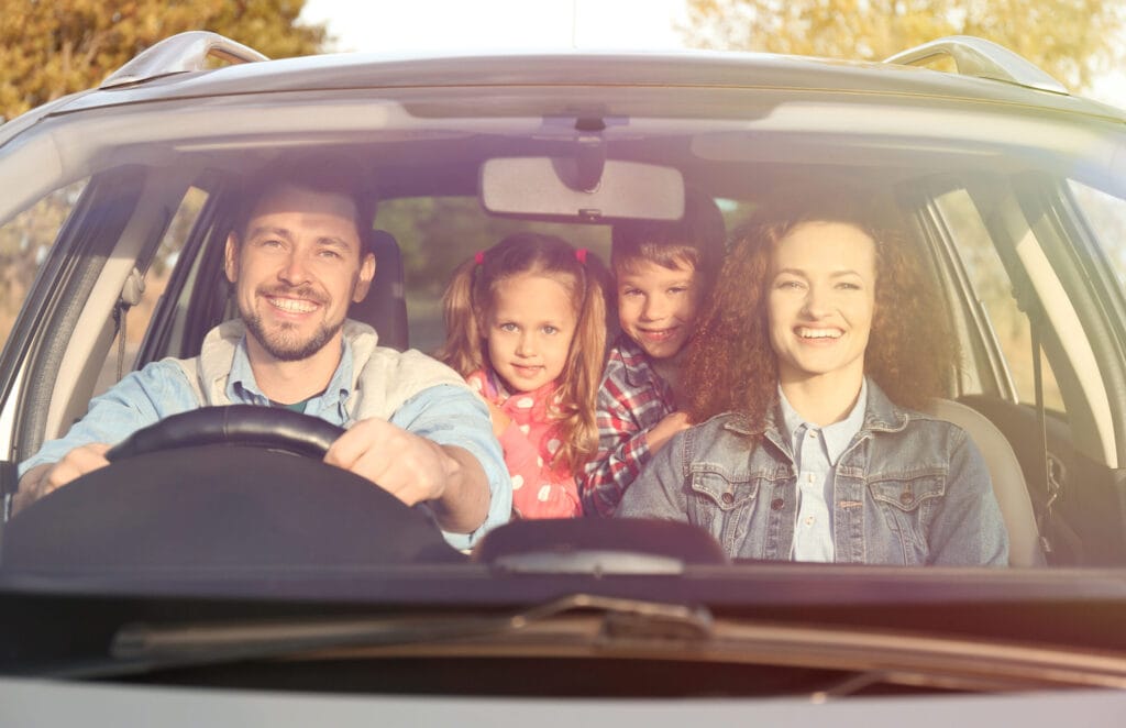 Gezin met kinderen in de auto passend bij een autoverzekering
